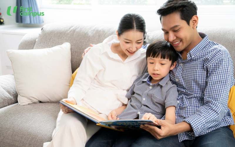 Tips for encouraging reading - parents should model reading by reading themselves. Image shows a mother and father reading a book with a young child on a sofa