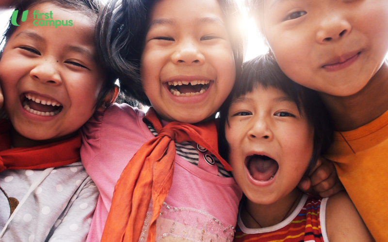 Four young preschool kids laughing, indicating that strong social skills are vital for their overall development