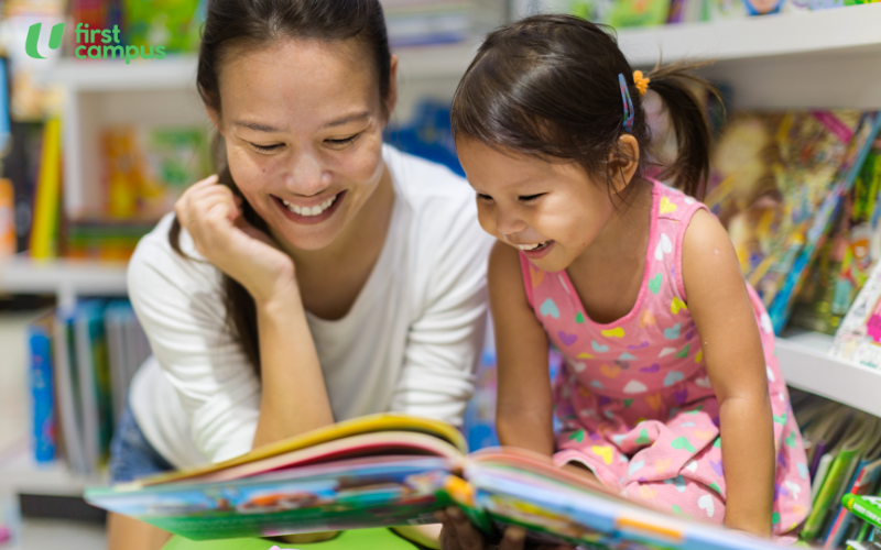 How to prepare your child for reading - create a literacy rich environment. The image shows a mother reading to her daughter in a room filled with children's books on the bookshelves.