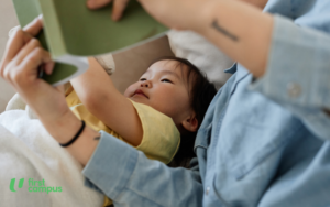 Reading literacy develops through various stages during early childhood, image shows a 0-2 year old reading in bed with a parent